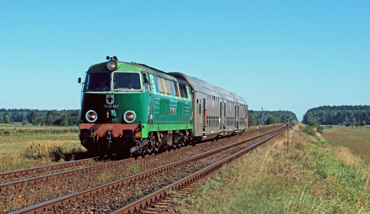 PKP SU45-197 takes a rake of three double-deck coaches as train 58833 from Tczew (PL) to Chojnice (PL) at Czarna Woda (PL) on 10 September 2004.